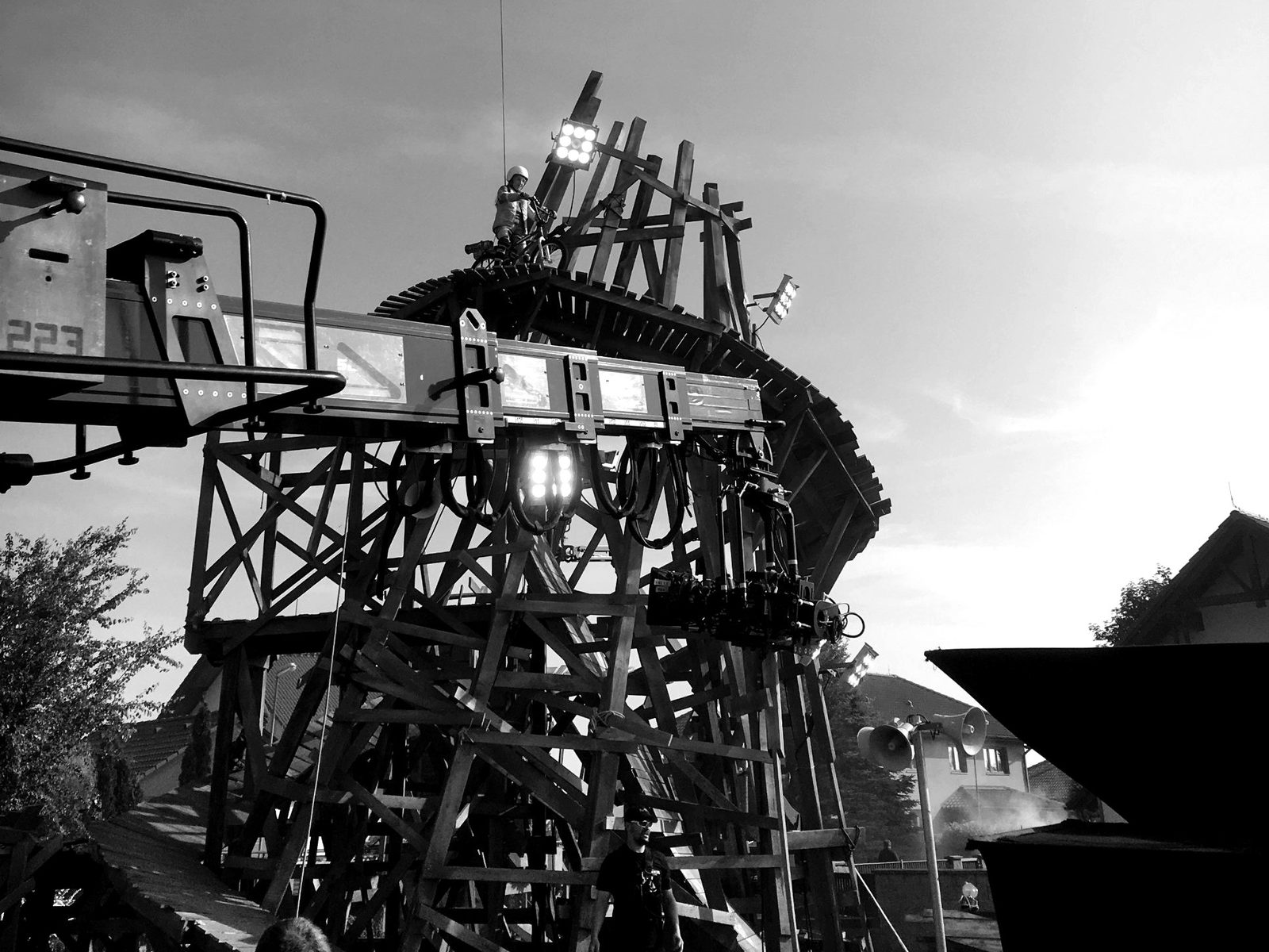 Filmset einer Bike-Produktion: Fahrer auf einem hohen Holz-Startturm, davor Kamerakran und Scheinwerfer
